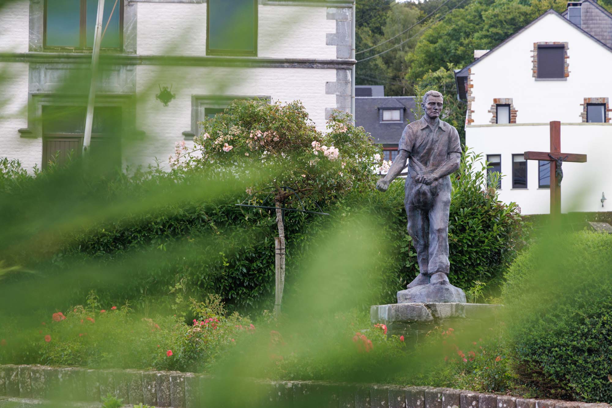 Statue à Mirwart sur une place publique devant des maisons ardennaises